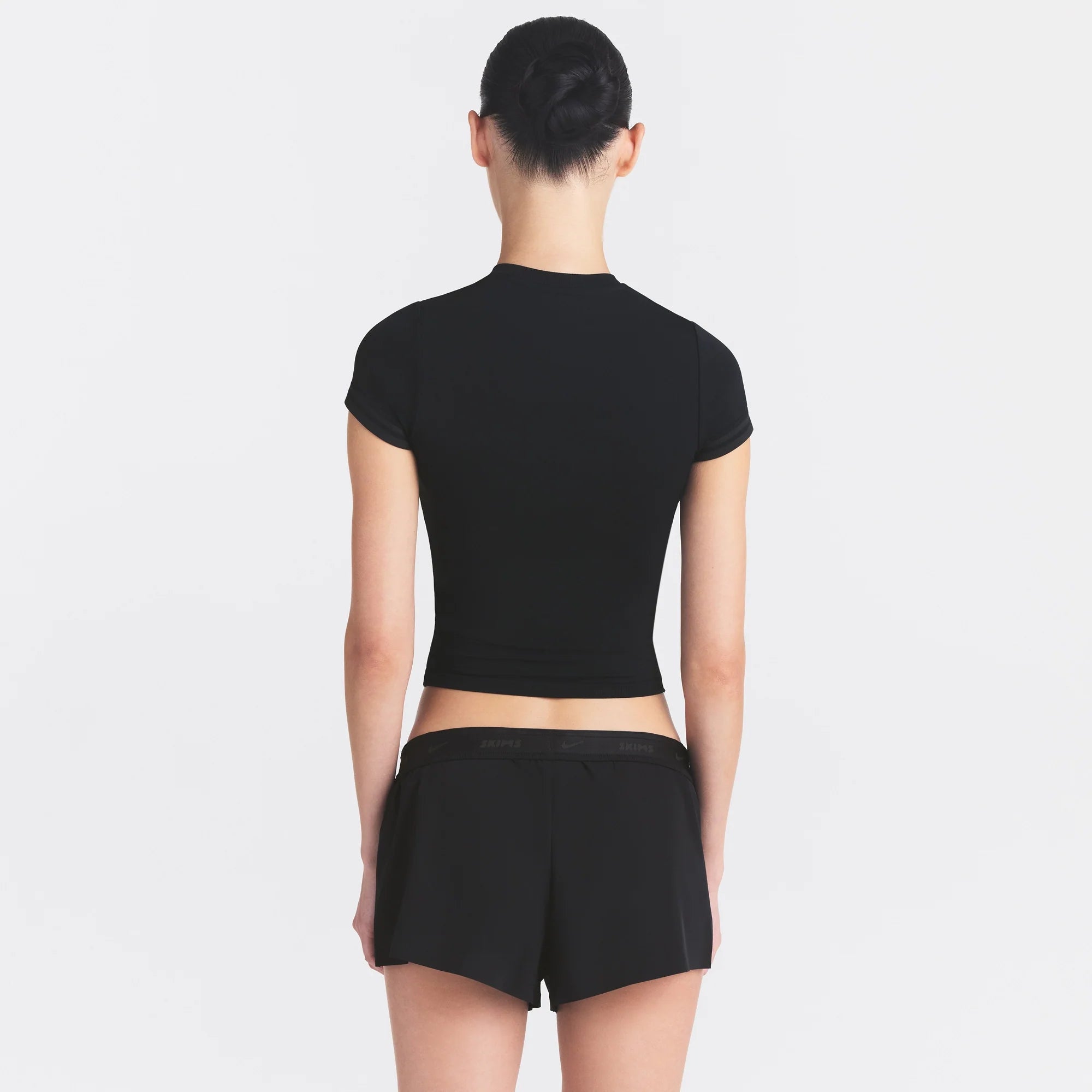 NikeSKIMS STRETCH KNIT CROPPED T-SHIRT | OBSIDIAN ON A MODEL SIDE VIEW @ | FOCUS: 0.0, 1.0, 0.9