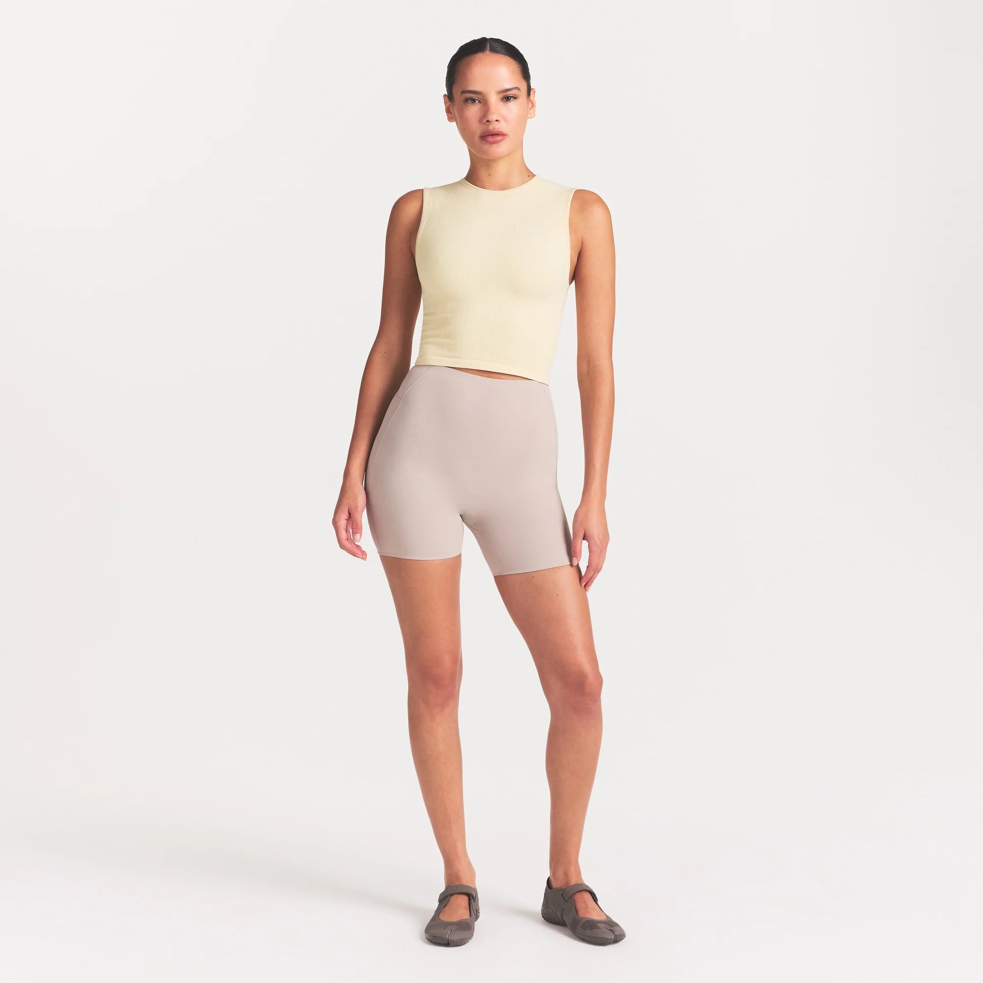 NikeSKIMS RIBBED SEAMLESS MUSCLE TANK | LEMON DROP ON A MODEL FRONT VIEW @ | FOCUS: 0.0, 1.0, 0.9