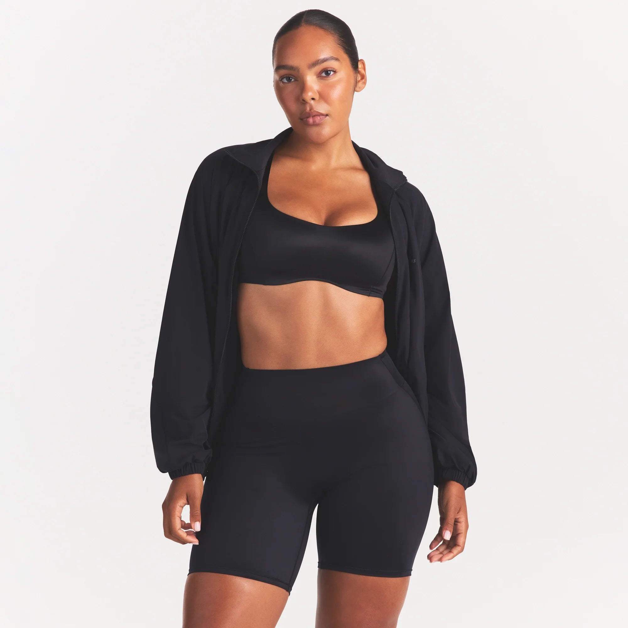 NikeSKIMS STRETCH NYLON OVERSIZED TRACK JACKET | OBSIDIAN ON A MODEL SIDE VIEW @ | FOCUS: 0.0, 1.0, 0.9