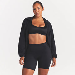 NikeSKIMS STRETCH NYLON OVERSIZED TRACK JACKET | OBSIDIAN ON A MODEL SIDE VIEW @ | FOCUS: 0.0, 1.0, 0.9