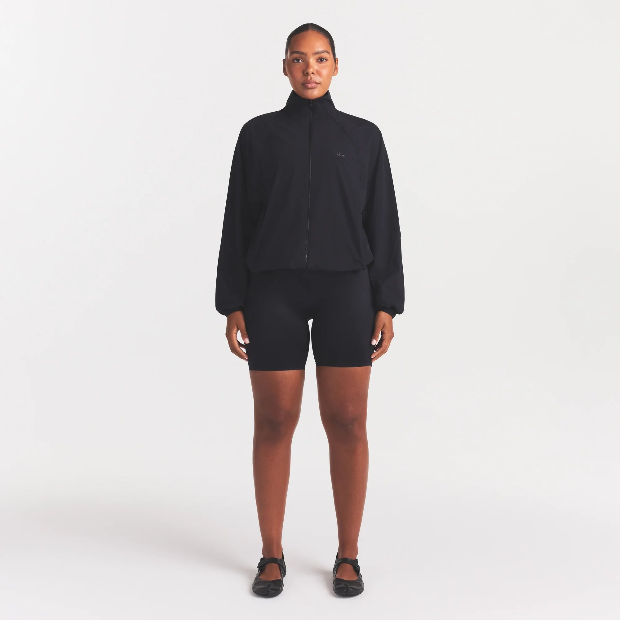 NikeSKIMS STRETCH NYLON OVERSIZED TRACK JACKET | OBSIDIAN ON A MODEL FRONT VIEW @ | FOCUS: 0.0, 1.0, 0.9