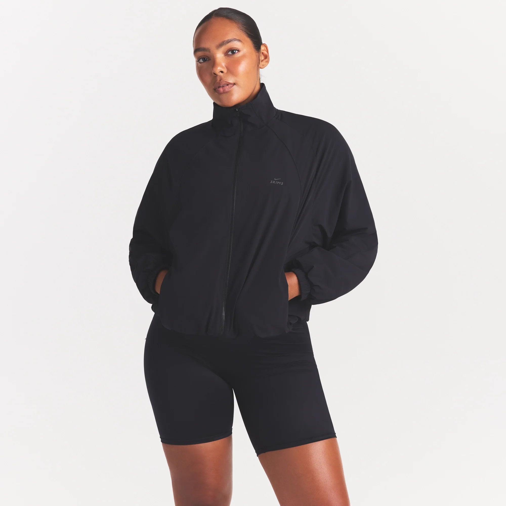 NikeSKIMS STRETCH NYLON OVERSIZED TRACK JACKET | OBSIDIAN ON A MODEL SIDE VIEW @ | FOCUS: 0.0, 1.0, 0.9