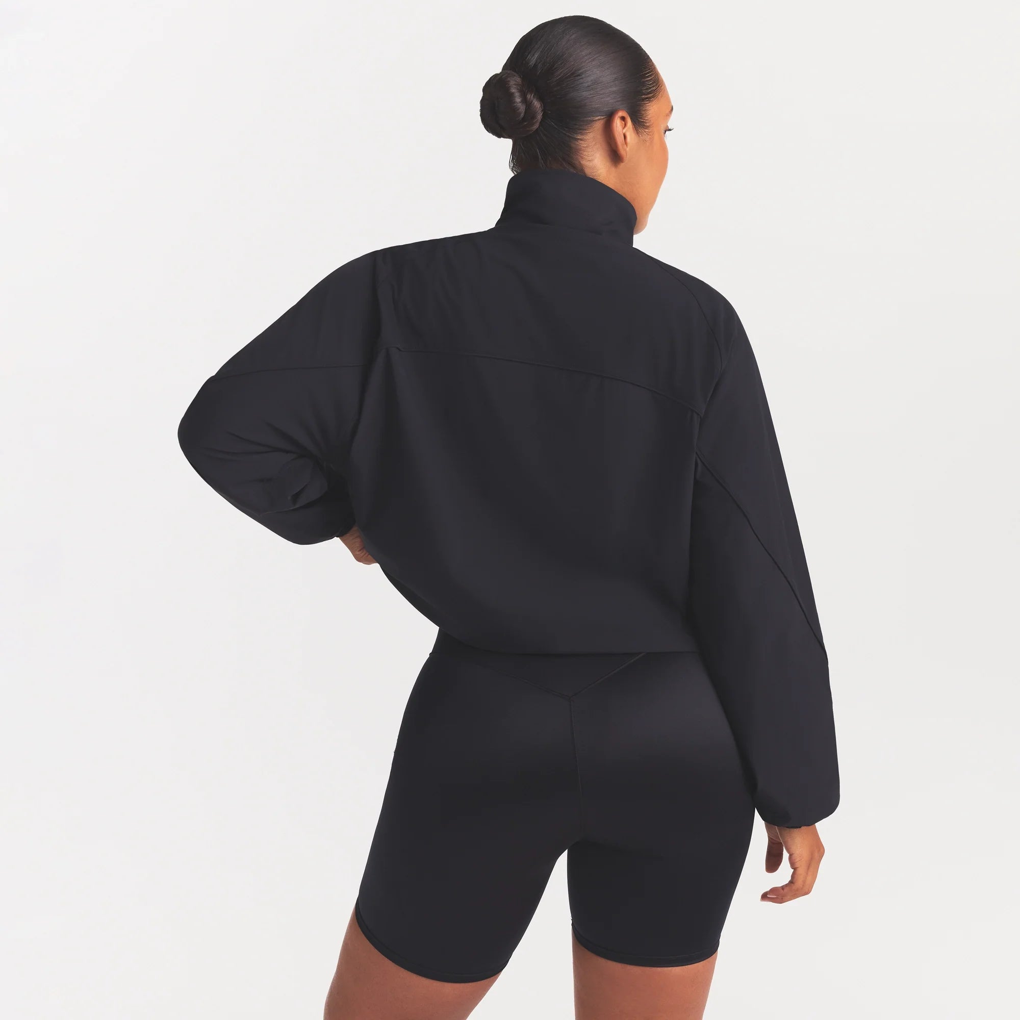 NikeSKIMS STRETCH NYLON OVERSIZED TRACK JACKET | OBSIDIAN ON A MODEL SIDE VIEW @ | FOCUS: 0.0, 1.0, 0.9