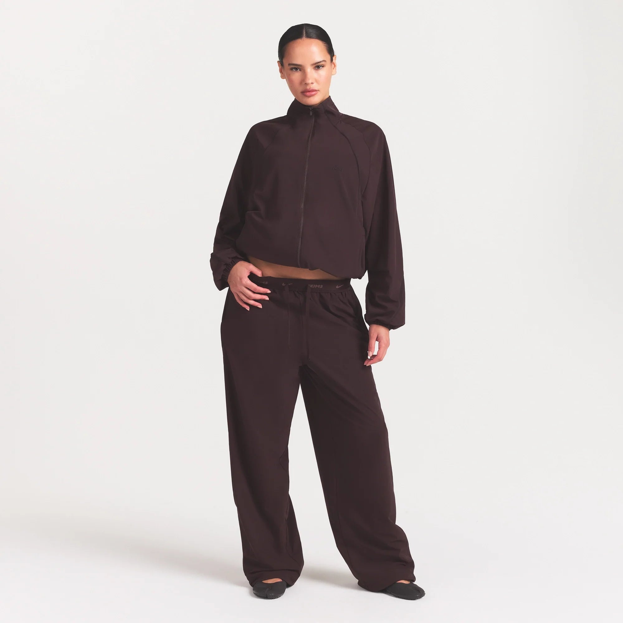 NikeSKIMS STRETCH NYLON OVERSIZED TRACK JACKET | DARK ROAST ON A MODEL FRONT VIEW @ | FOCUS: 0.0, 1.0, 0.9