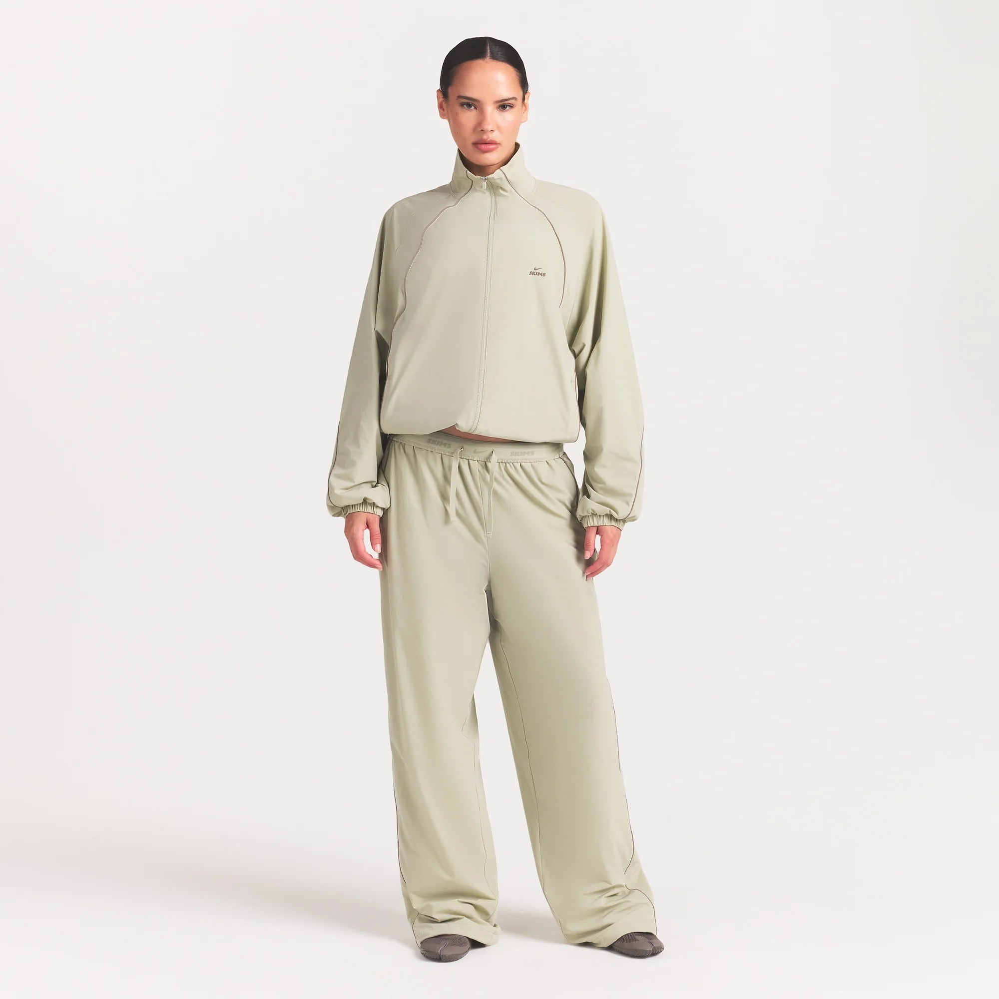 NikeSKIMS STRETCH NYLON OVERSIZED TRACK JACKET | TALC ON A MODEL FRONT VIEW @ | FOCUS: 0.0, 1.0, 0.9