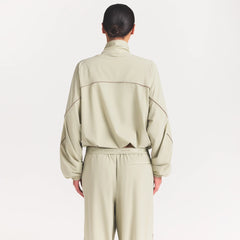 NikeSKIMS STRETCH NYLON OVERSIZED TRACK JACKET | TALC ON A MODEL SIDE VIEW @ | FOCUS: 0.0, 1.0, 0.9