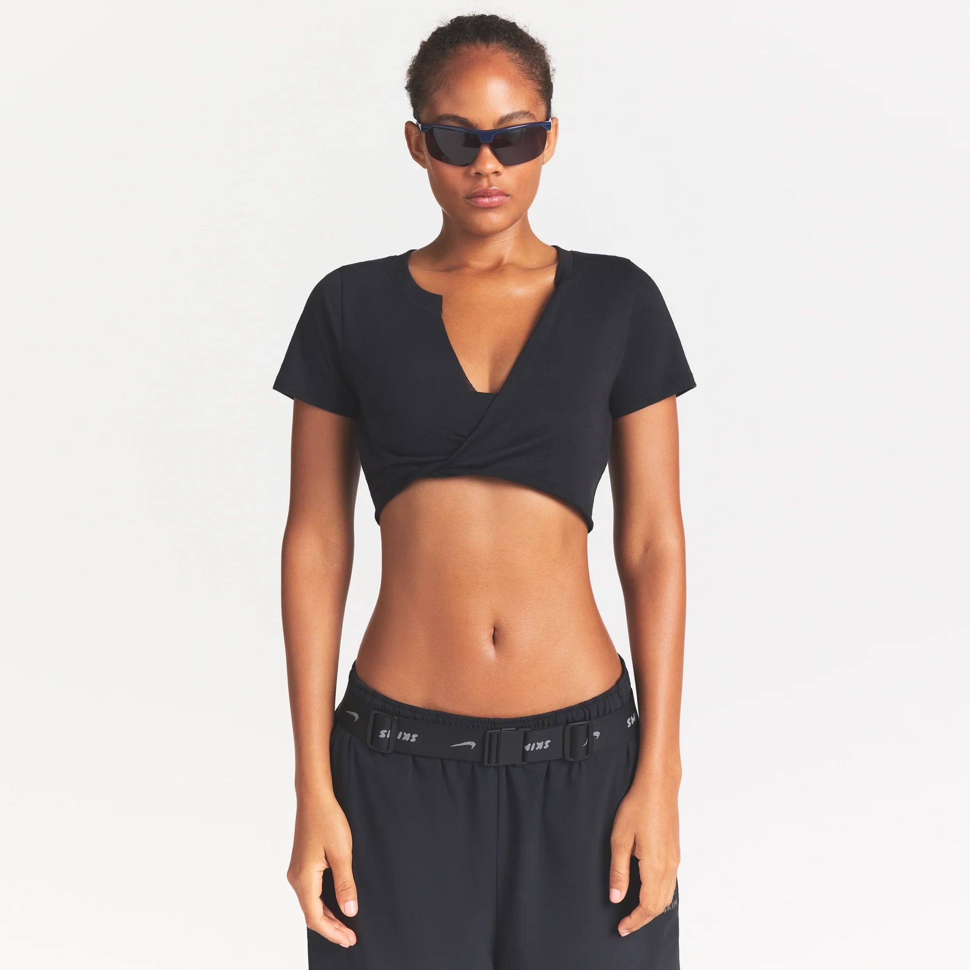 NikeSKIMS PERFORMANCE COTTON BLEND CROP TWIST TANK | OBSIDIAN ON A MODEL SIDE VIEW @ | FOCUS: 0.0, 1.0, 0.9
