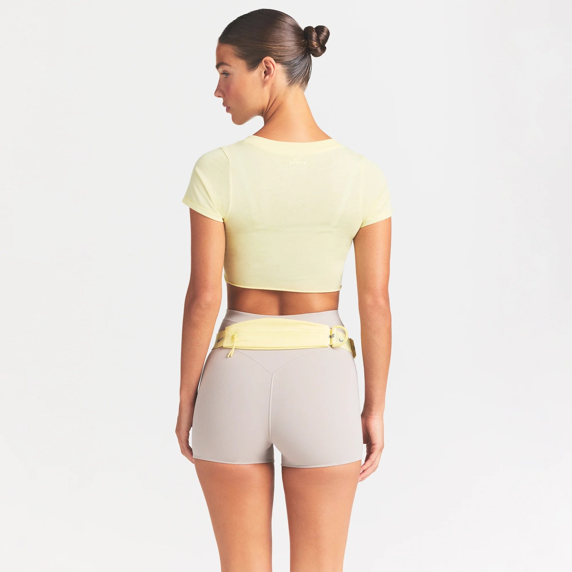 NikeSKIMS PERFORMANCE COTTON BLEND SHORT SLEEVE V-NECK TOP | BICYCLE YELLOW ON A MODEL SIDE VIEW