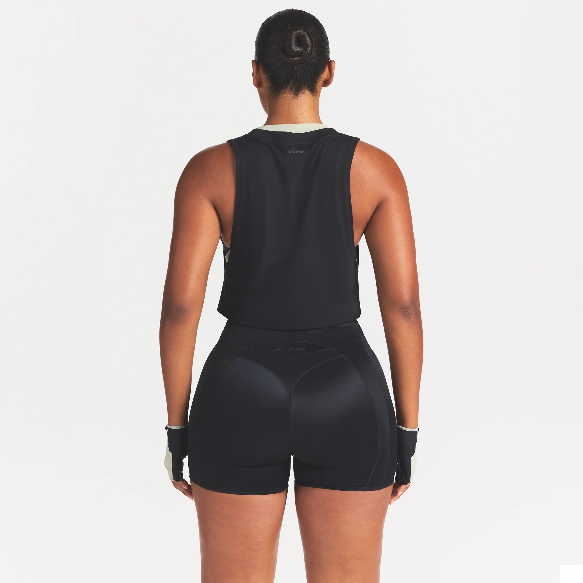 NikeSKIMS PERFORMANCE COTTON BLEND CROP TANK | OBSIDIAN ON A MODEL SIDE VIEW @ | FOCUS: 0.0, 1.0, 0.9