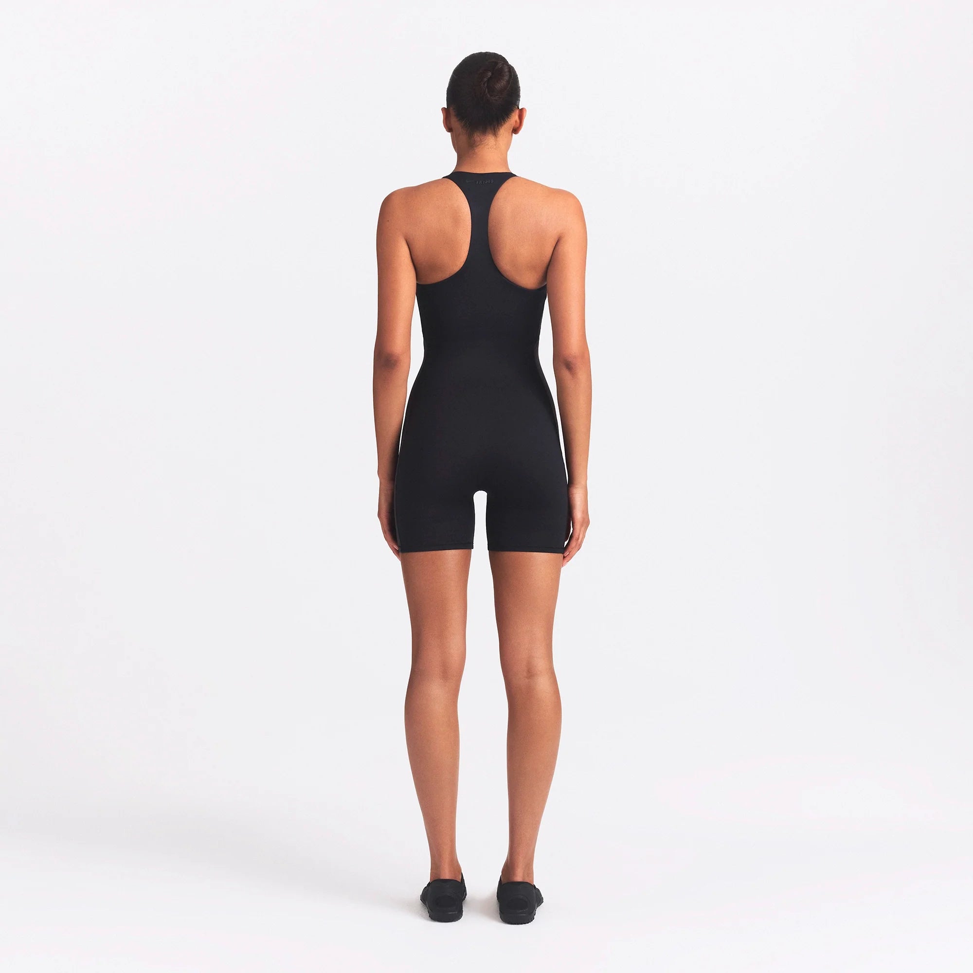 NikeSKIMS MATTE AND SHINE RACERBACK 5" ONE PIECE | OBSIDIAN/IGNEOUS ON A MODEL SIDE VIEW @ | FOCUS: 0.0, 1.0, 0.9