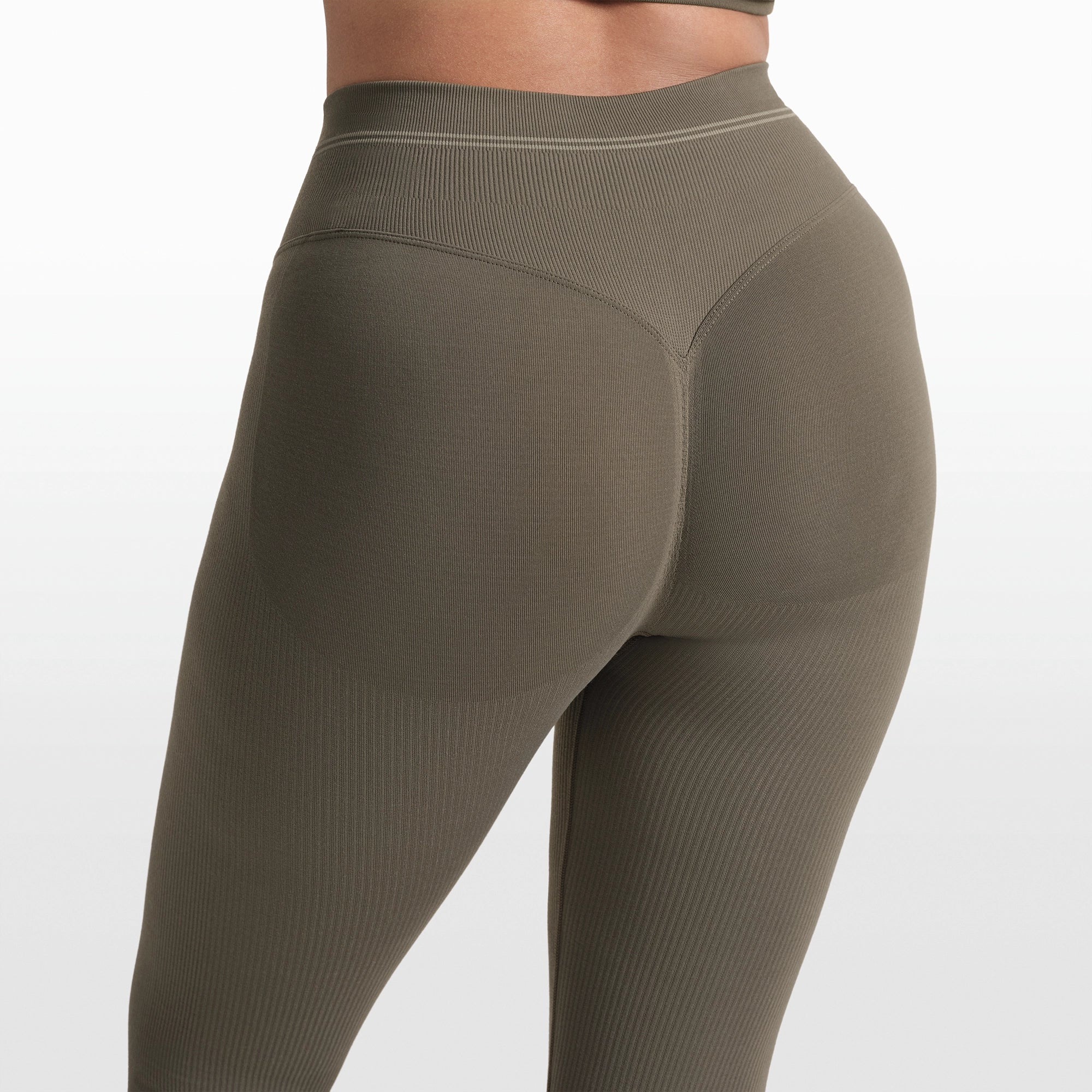 NikeSKIMS RIBBED SEAMLESS 26" LEGGING | DUSTY OAKMOSS/DUNE ON A MODEL FRONT VIEW @ | FOCUS: 0.0, 1.0, 0.9