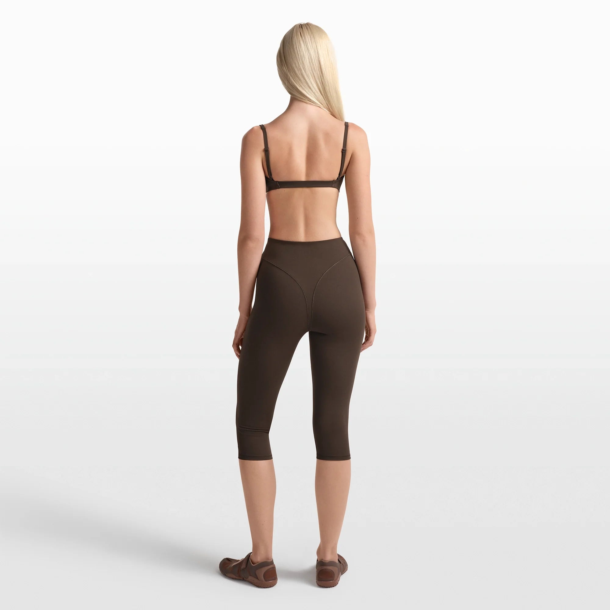 NikeSKIMS MATTE 17" V-LINE CROP LEGGING | DARK SEPIA ON A MODEL FRONT VIEW @ | FOCUS: 0.0, 1.0, 0.9