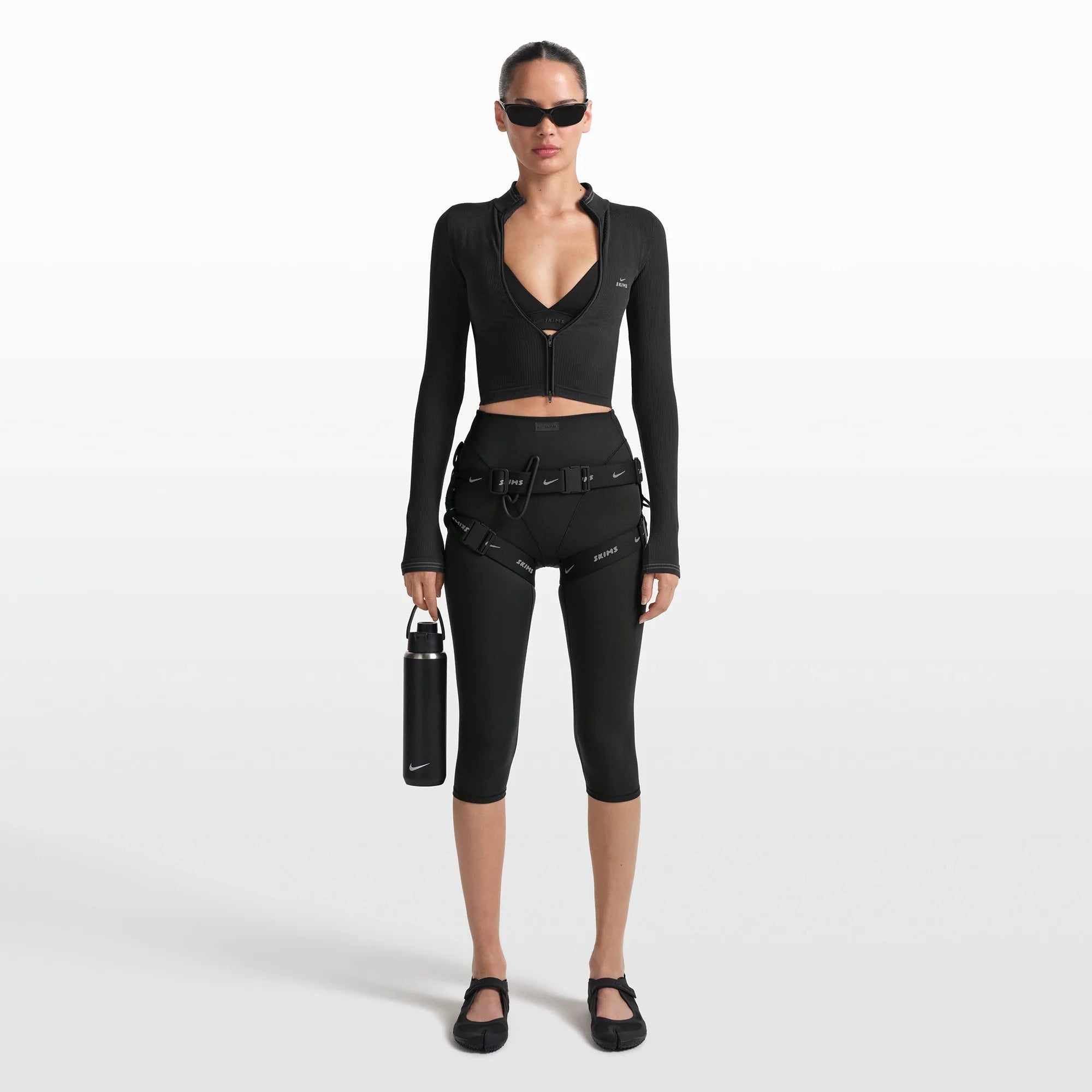 NikeSKIMS MATTE 17" V-LINE CROP LEGGING | OBSIDIAN ON A MODEL FRONT VIEW @ | FOCUS: 0.0, 1.0, 0.9