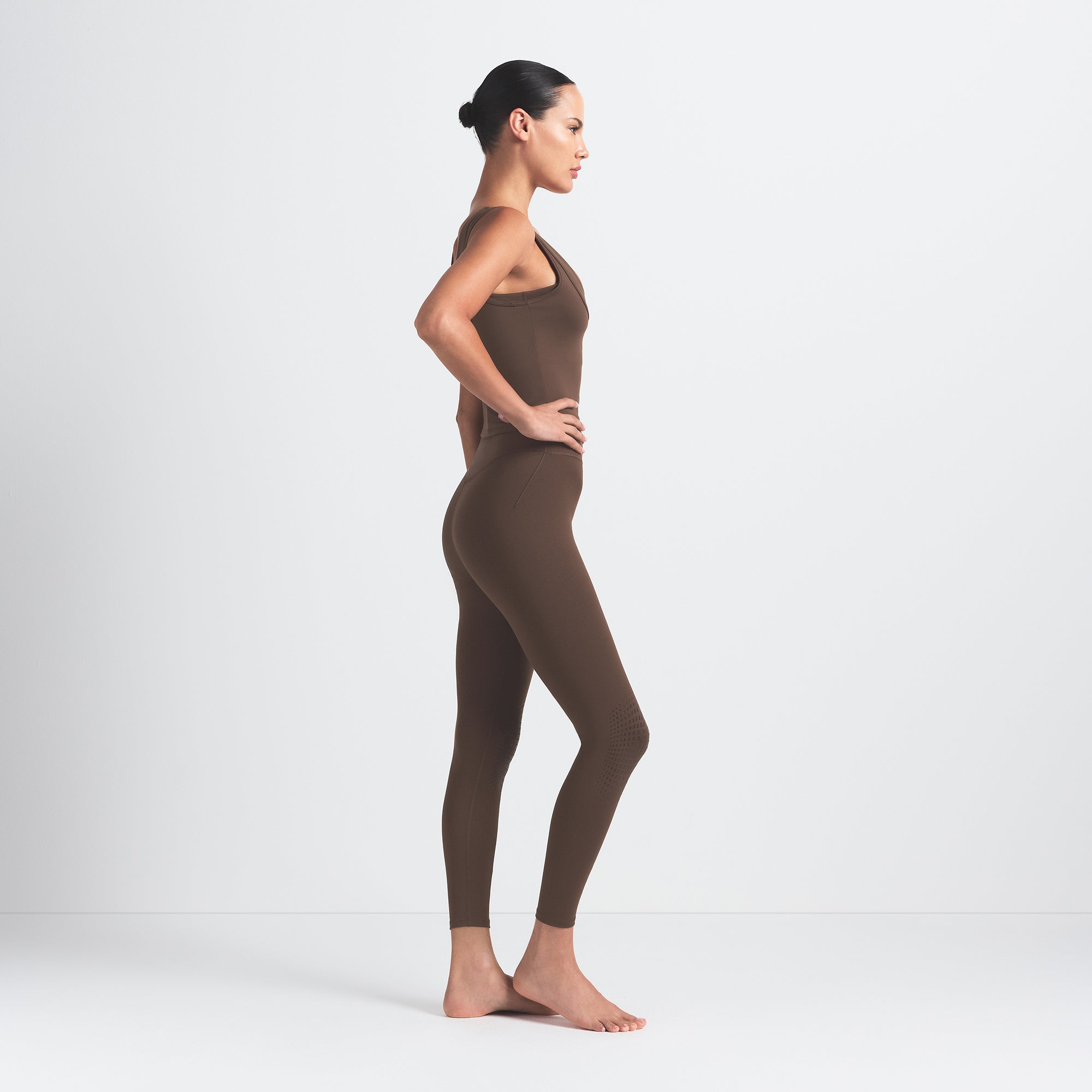 NikeSKIMS MATTE KNEE GRIP 26" LEGGING | DARK SEPIA ON A MODEL SIDE VIEW @ | FOCUS: 0.0, 1.0, 0.9