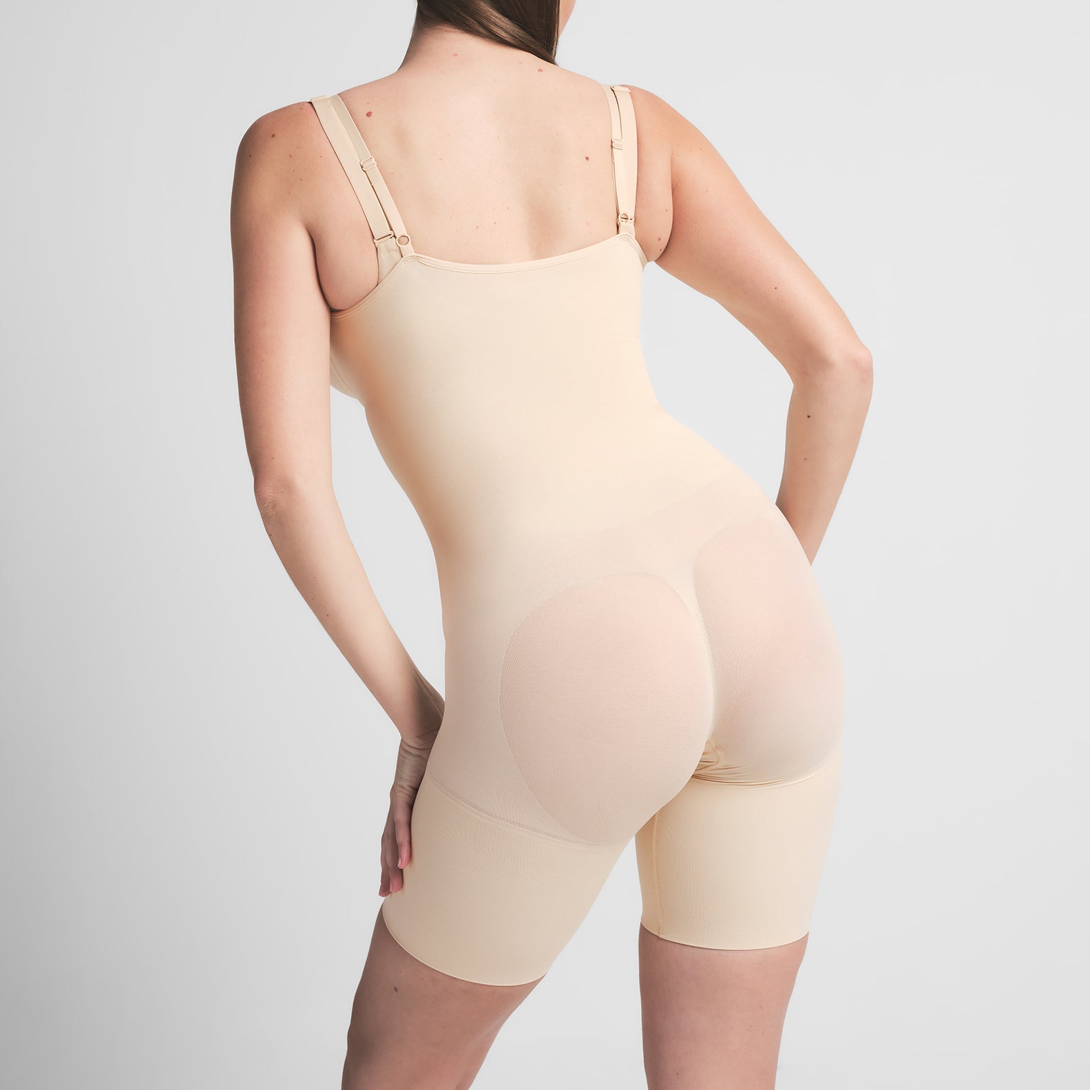 SEAMLESS SCULPT BUTT LIFTING OPEN BUST BODYSUIT | SAND ON A MODEL BACK VIEW
