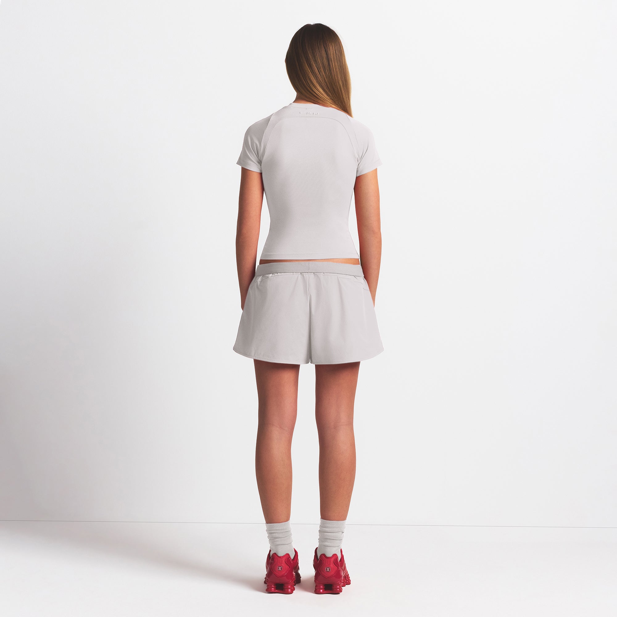 NikeSKIMS WOVEN NYLON 2.5" RUNNER SHORT | STONE ON A MODEL BACK VIEW @ | FOCUS: 0.9, 0.1, 0.7