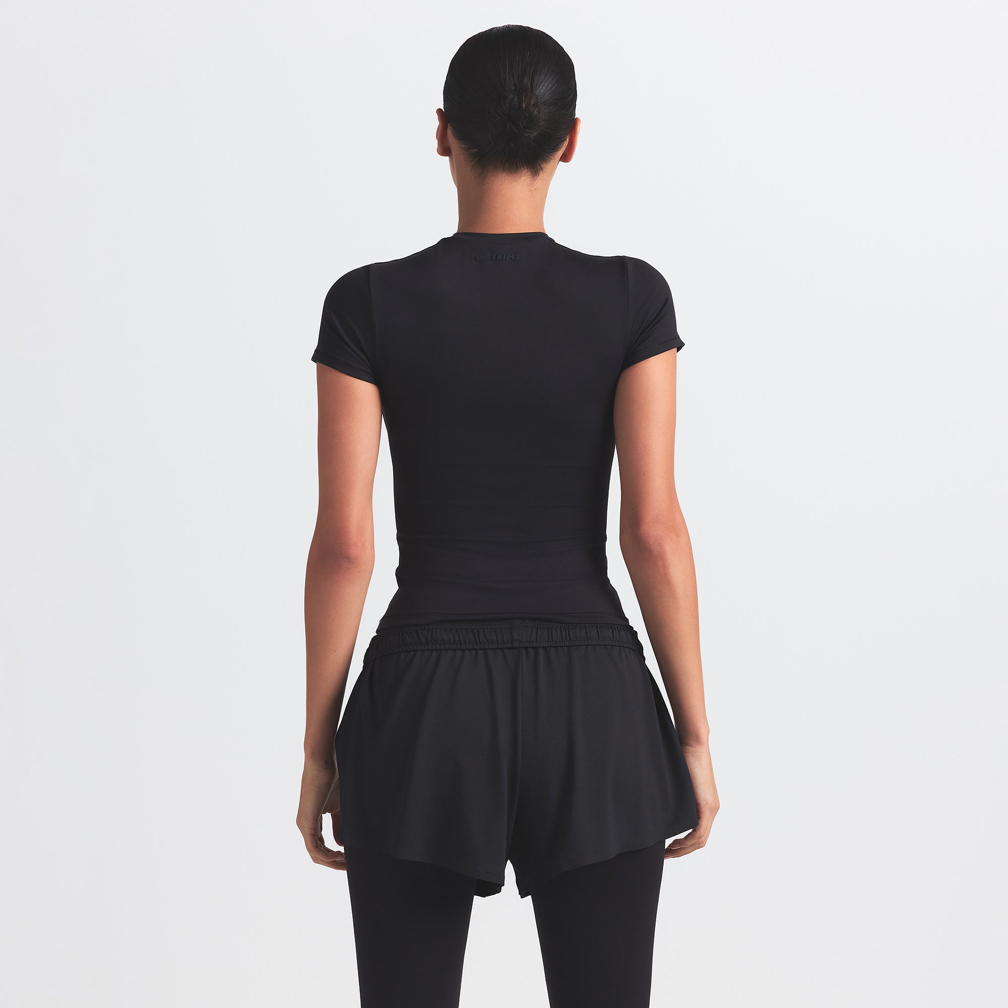NikeSKIMS AIRY MINI SHORT | OBSIDIAN ON A MODEL BACK VIEW @ | FOCUS: 0.9, 0.1, 0.7