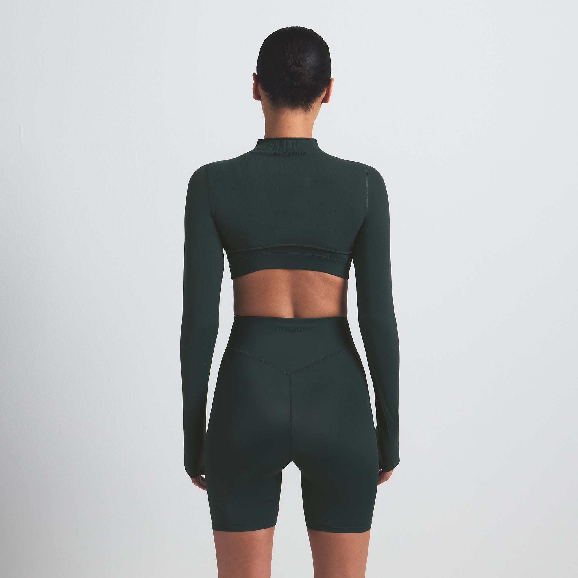 NikeSKIMS SHINE BONDED WAIST 5" BIKER SHORT | DARK TEAL ON A MODEL SIDE VIEW @ | FOCUS: 0.0, 1.0, 0.9