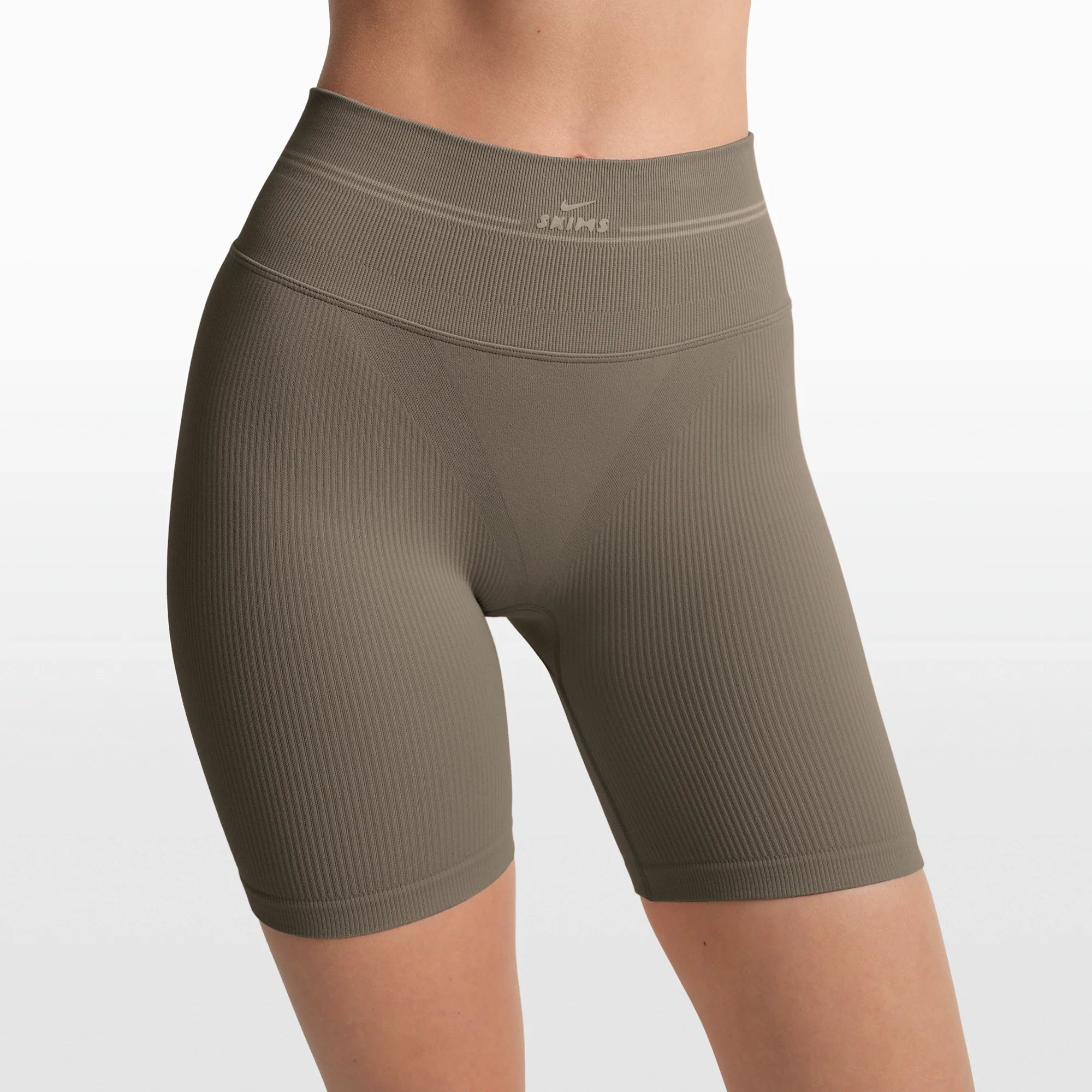 NikeSKIMS RIBBED SEAMLESS 5" BIKER SHORT | DUSTY OAKMOSS/DUNE ON A MODEL FRONT VIEW @ | FOCUS: 0.0, 1.0, 0.9