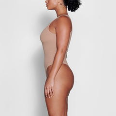 A MODEL STANDS SIDEWAYS SHOWING THE PROFILE OF THE FITS EVERYBODY HIGH NECK BODYSUIT | SIENNA