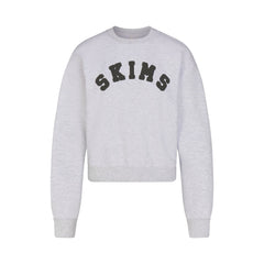 COTTON FLEECE CLASSIC CREWNECK | LIGHT HEATHER GREY WITH ONYX LOGO FLAT ON A WHITE BACKGROUND | FLT