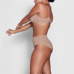 A MODEL STANDS SIDEWAYS SHOWING THE PROFILE OF THE FITS EVERYBODY FULL BRIEF | SIENNA