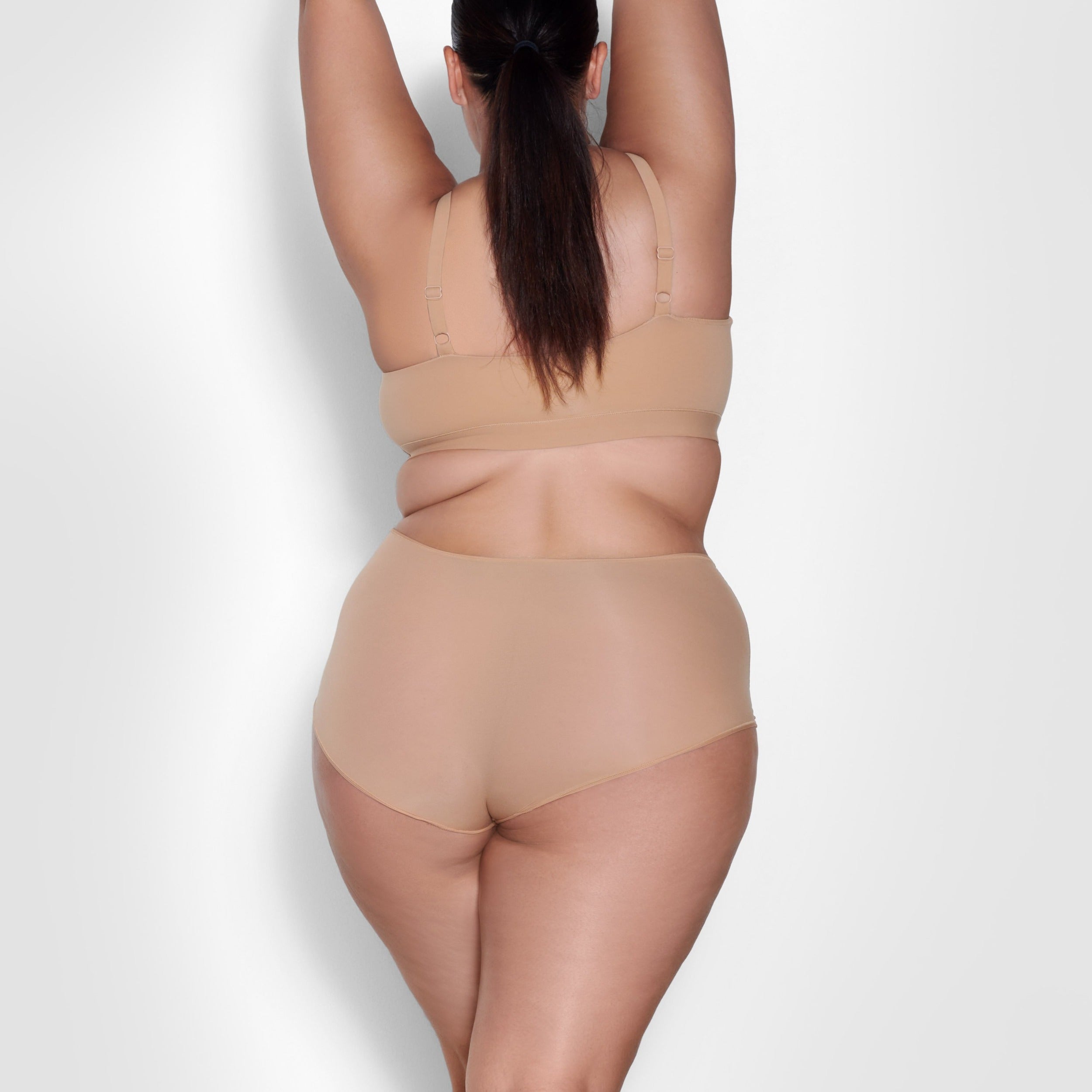 A MODEL STANDS WITH HER BACK TO THE CAMERA SHOWING THE FITS EVERYBODY BOY SHORT | OCHRE