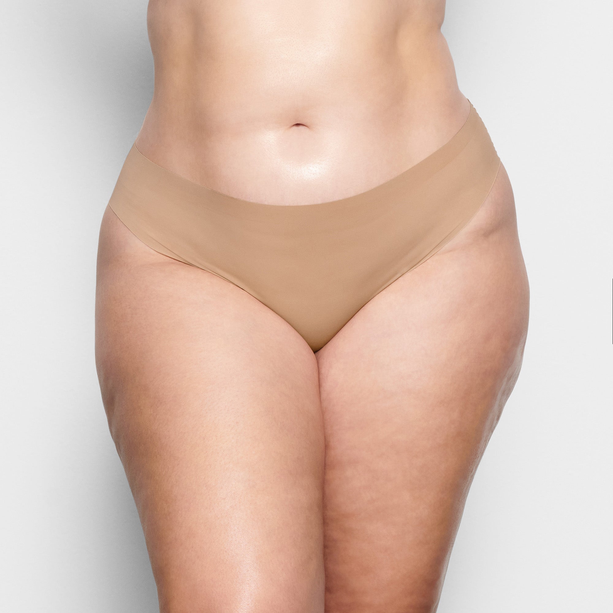 ON A MODEL FRONT VIEW FREE CUT MID WAIST TANGA IN CLAY  | FOCUS: 0.1, 0.9, 0.9