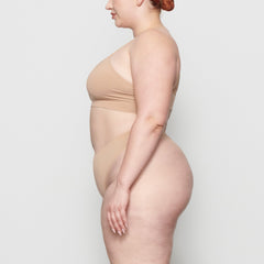 SOFT SMOOTHING THONG WORN BY A MODEL IN SIDE VIEW