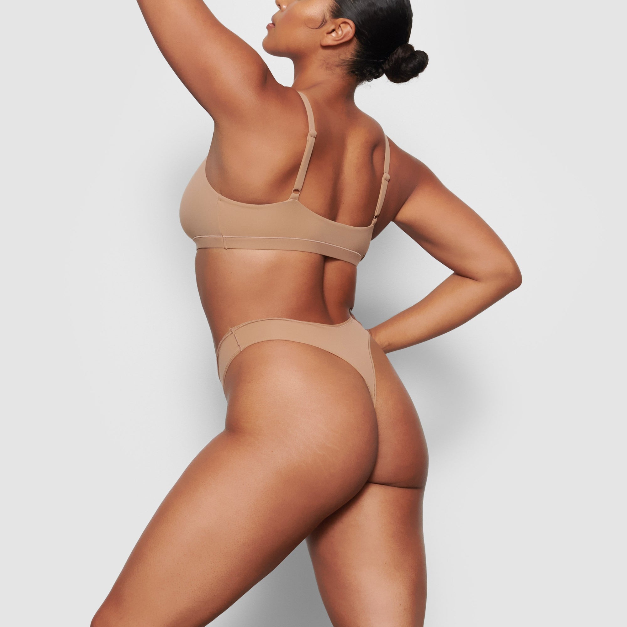 A MODEL STANDS SIDEWAYS SHOWING THE PROFILE OF THE FITS EVERYBODY THONG | SIENNA