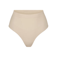 SEAMLESS SCULPT MID WAIST THONG | SAND (SHAPEWEAR THONGS, PANTIES) LAYS FLAT ON A WHITE BACKGROUND | FLT