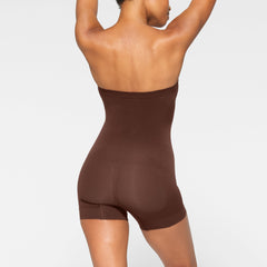SEAMLESS SCULPT STRAPLESS MID THIGH BODYSUIT ON A MODEL BACK VIEW