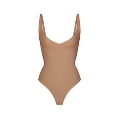 SKIMS BODY CORE SCULPT PLUNGE THONG BODYSUIT | SIENNA (SHAPEWEAR BODYSUITS) FLAT ON A WHITE BACKGROUND | FLT