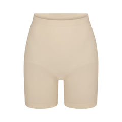 SEAMLESS SCULPT MID THIGH SHORT | SAND (SHAPEWEAR SHORTS, SHAPEWEAR) LAYS FLAT ON A WHITE BACKGROUND | FLT