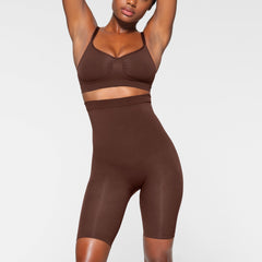 SEAMLESS SCULPT HIGH-WAISTED ABOVE THE KNEE SHORT WORN BY A MODEL IN FRONT VIEW 