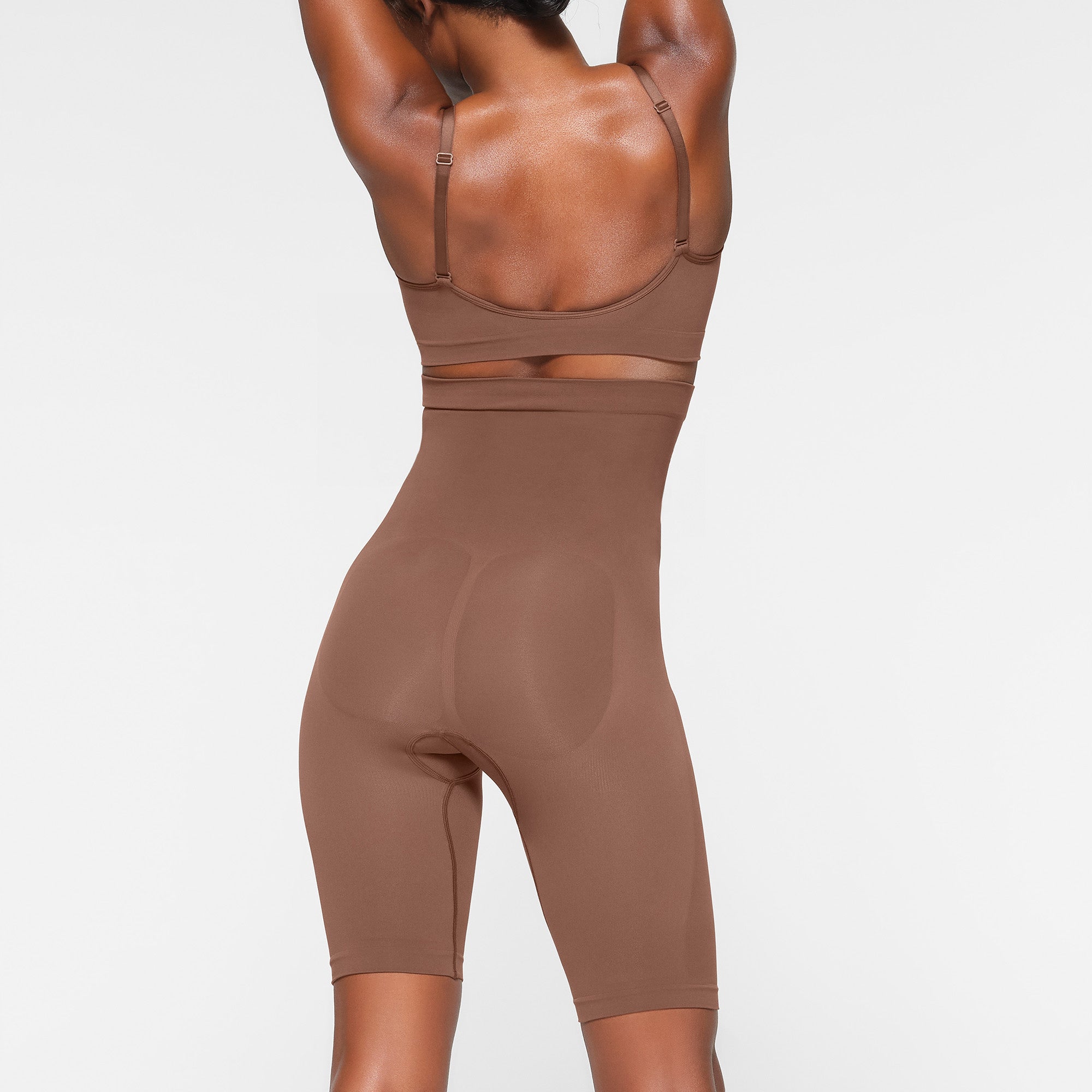 SEAMLESS SCULPT HIGH-WAISTED ABOVE THE KNEE SHORT ON A MODEL BACK VIEW