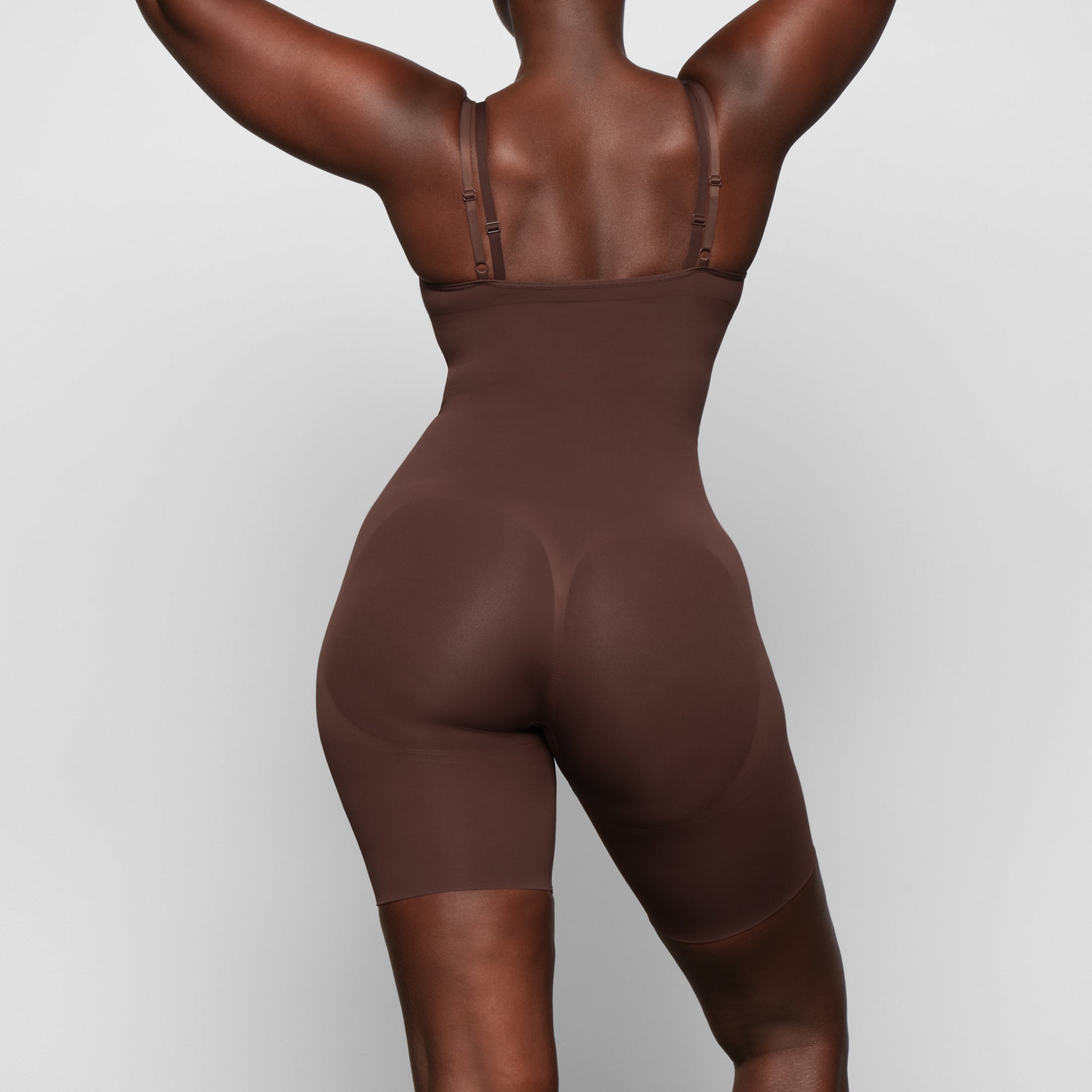 BUTT ENHANCING OPEN BUST BODYSUIT ON A MODEL BACK VIEW