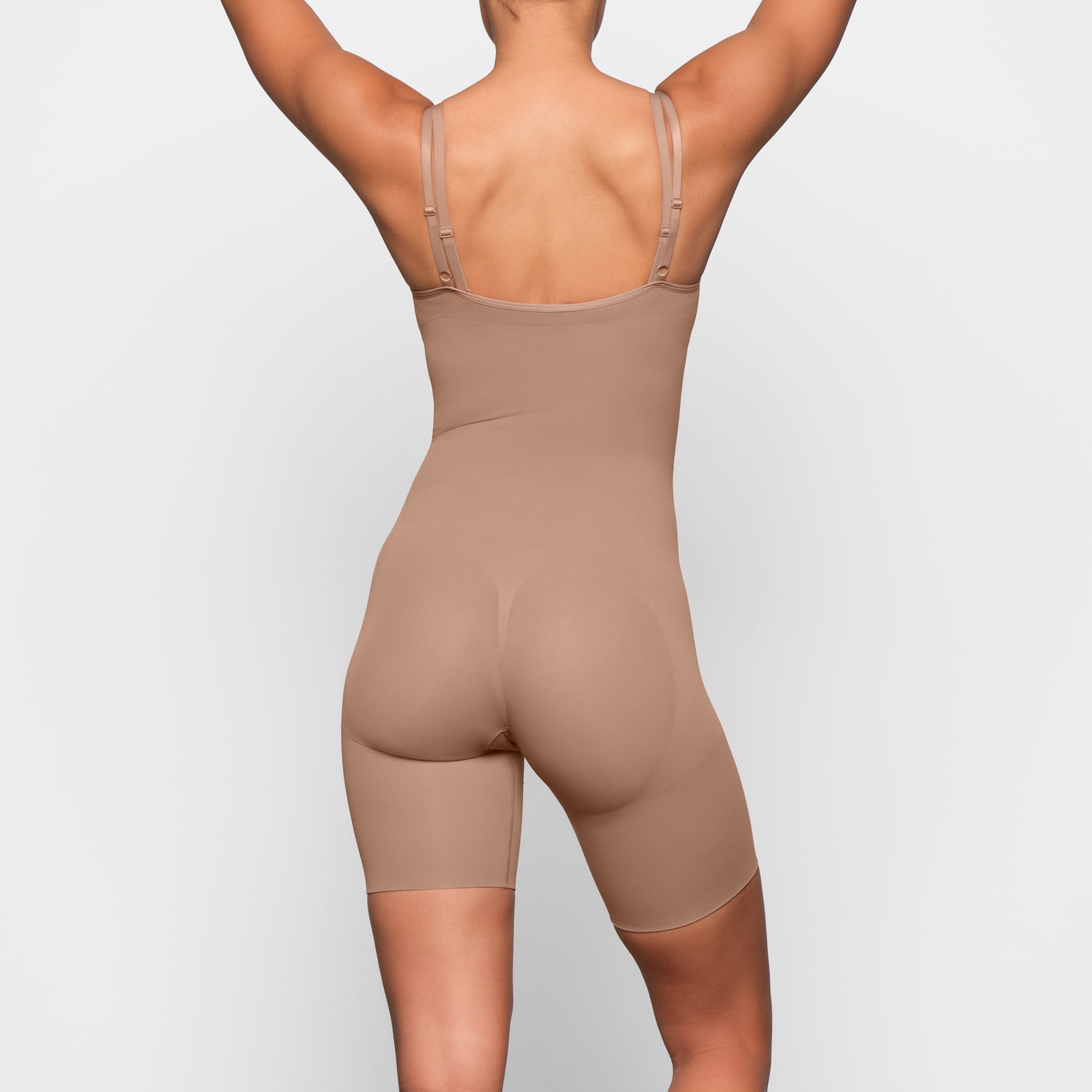 BUTT ENHANCING OPEN BUST BODYSUIT ON A MODEL BACK VIEW