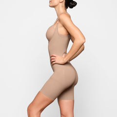 BUTT ENHANCING OPEN BUST BODYSUIT WORN BY A MODEL IN FRONT VIEW 