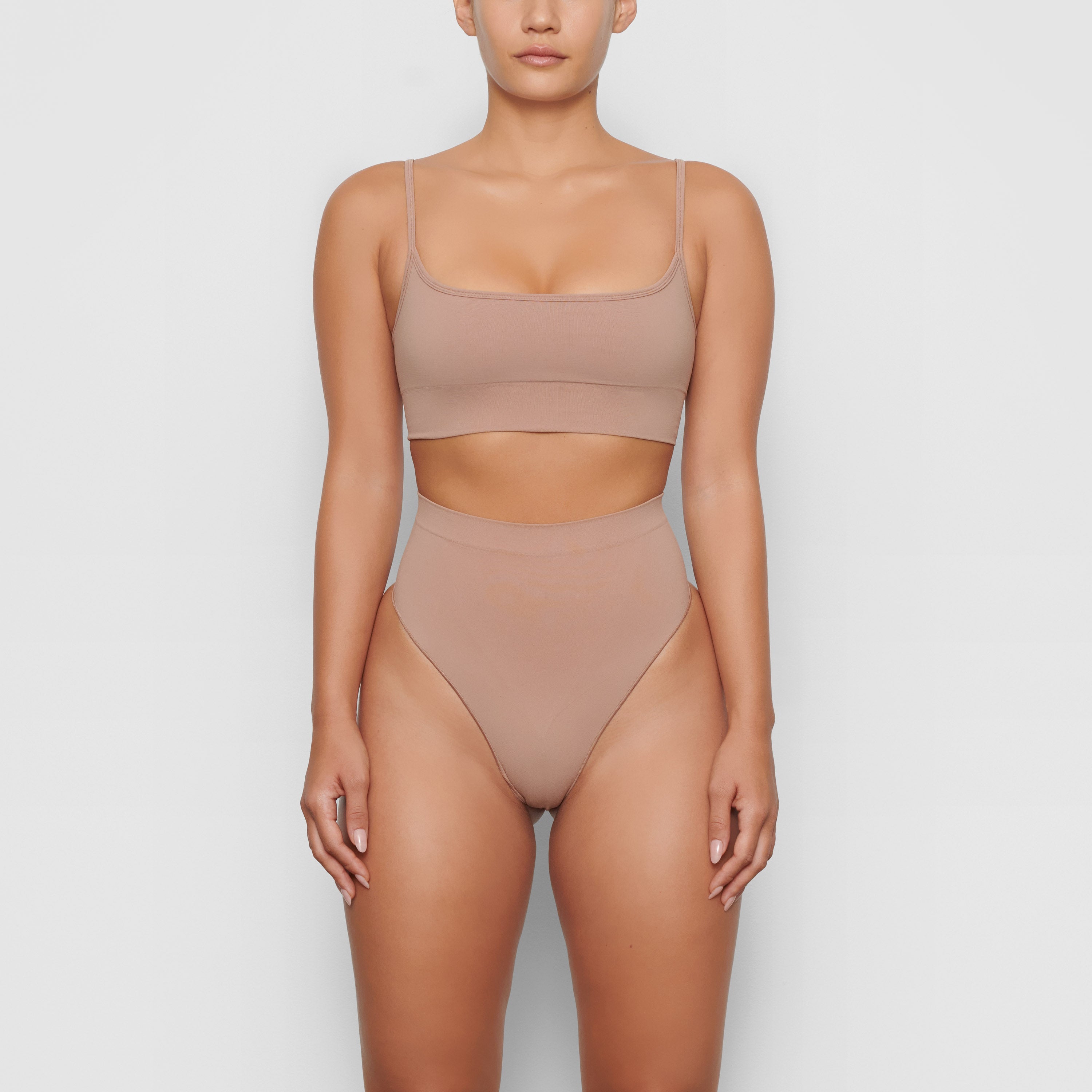 SEAMLESS SCULPT MID WAIST THONG WORN BY A MODEL IN FRONT VIEW, XL