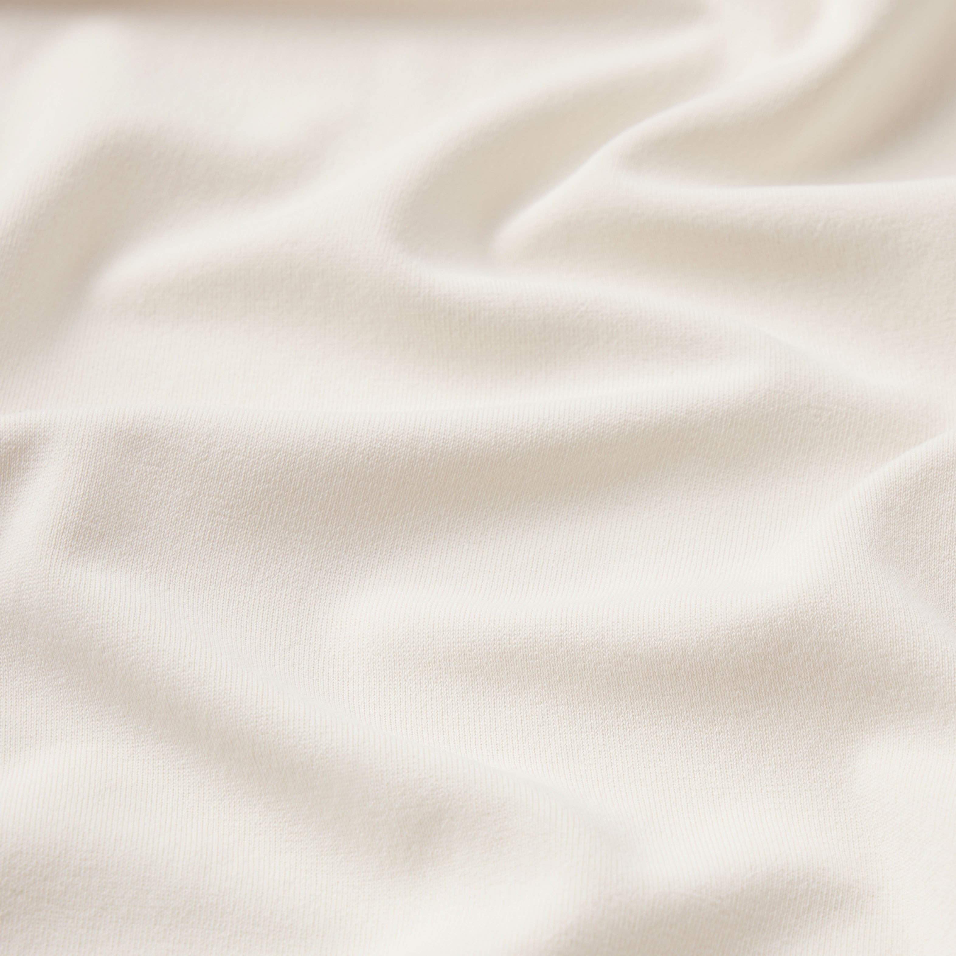 NikeSKIMS STRETCH KNIT CROPPED T-SHIRT | IVORY & LAYS FLAT ON A WHITE BACKGROUND | FLT