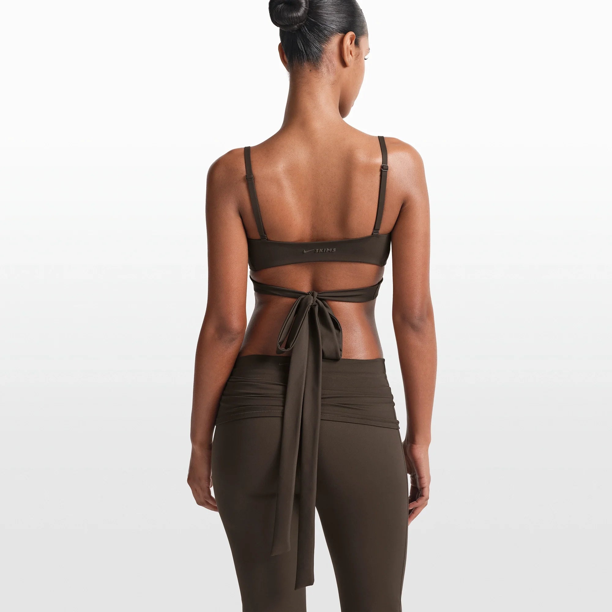 NikeSKIMS MATTE WRAP FRONT BRA | DARK SEPIA ON A MODEL FRONT VIEW @ | FOCUS: 0.0, 1.0, 0.9