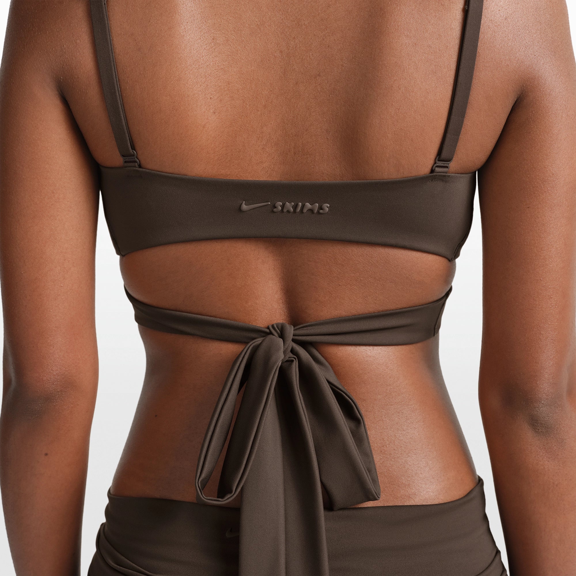 NikeSKIMS MATTE WRAP FRONT BRA | DARK SEPIA ON A MODEL FRONT VIEW @ | FOCUS: 0.0, 1.0, 0.9