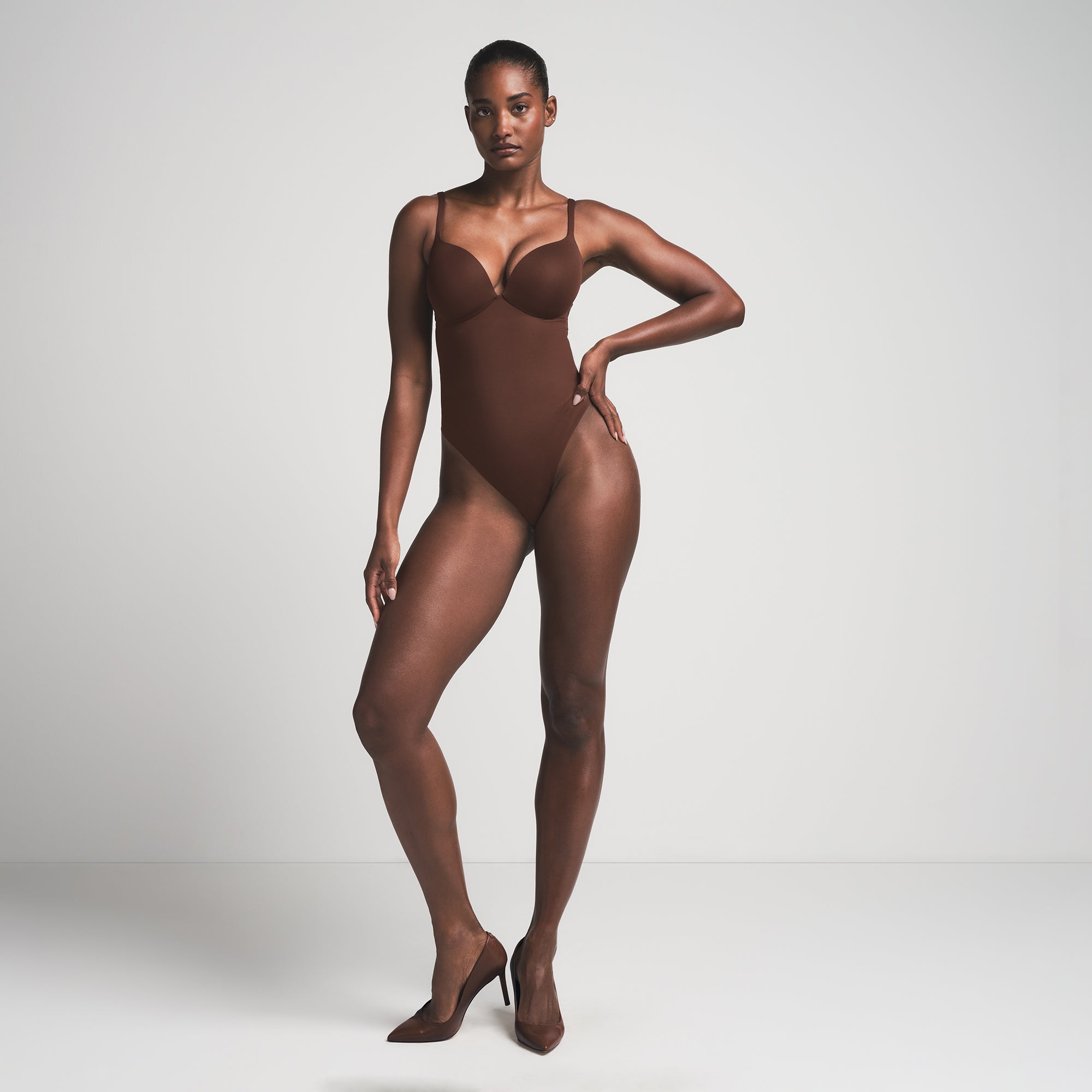 SKIMS ULTIMATE BODY PUSH-UP THONG BODYSUIT | COCOA  ON A MODEL FRONT VIEW