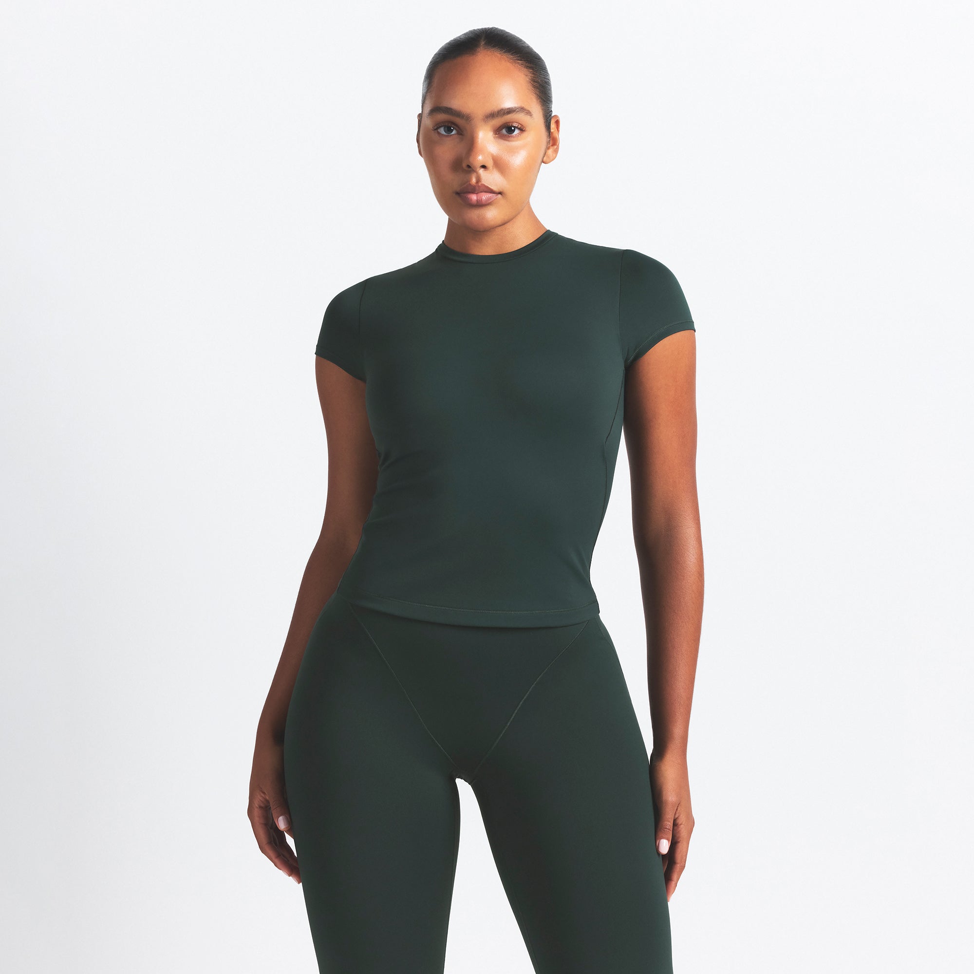 NikeSKIMS MATTE PADDED BABY TEE | DARK TEAL ON A MODEL SIDE VIEW @ | FOCUS: 0.0, 1.0, 0.9