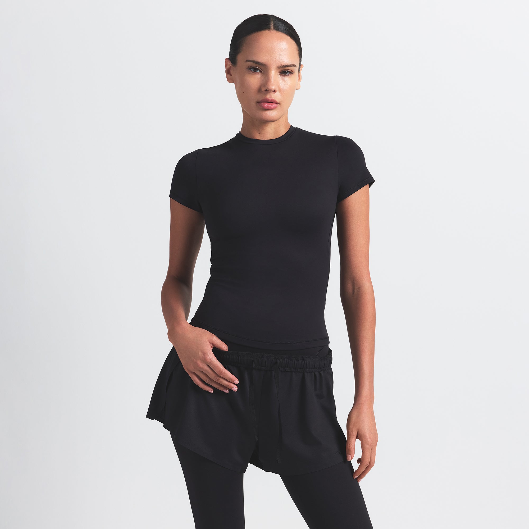 NikeSKIMS MATTE PADDED BABY TEE | OBSIDIAN ON A MODEL FRONT VIEW @ | FOCUS: 0.0, 1.0, 0.9