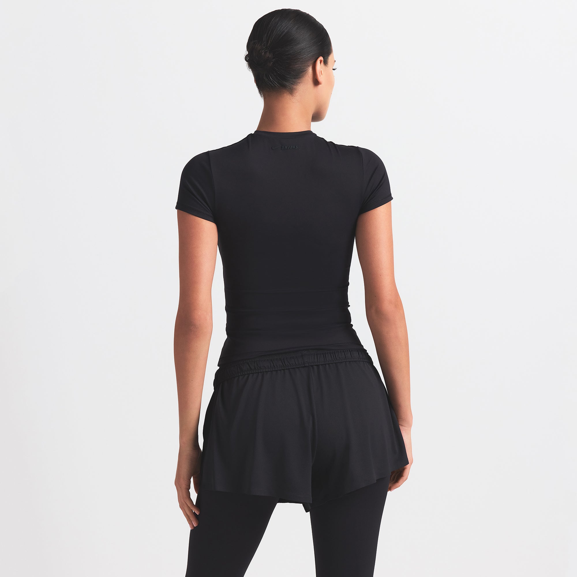 NikeSKIMS MATTE PADDED BABY TEE | OBSIDIAN ON A MODEL BACK VIEW @ | FOCUS: 0.0, 1.0, 0.9