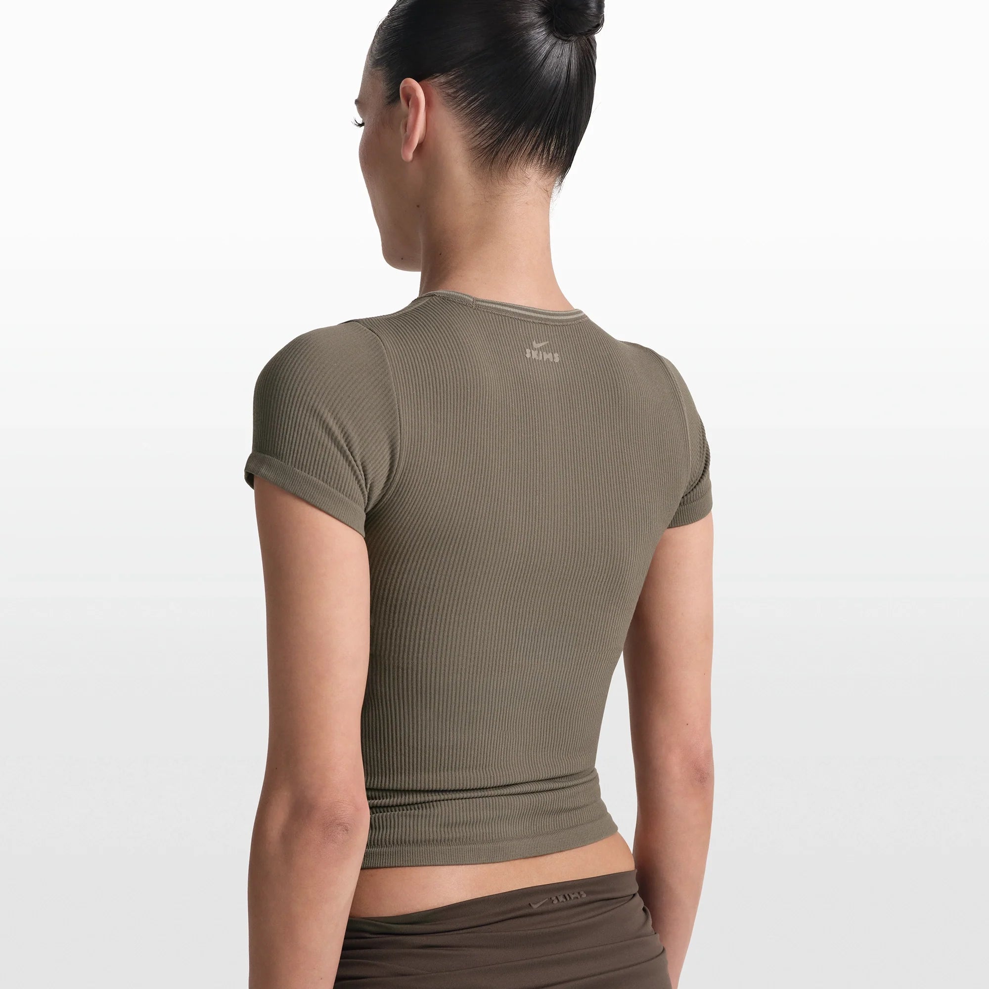 NikeSKIMS RIBBED SEAMLESS BABY TEE | DUSTY OAKMOSS/DUNE ON A MODEL FRONT VIEW @ | FOCUS: 0.0, 1.0, 0.9