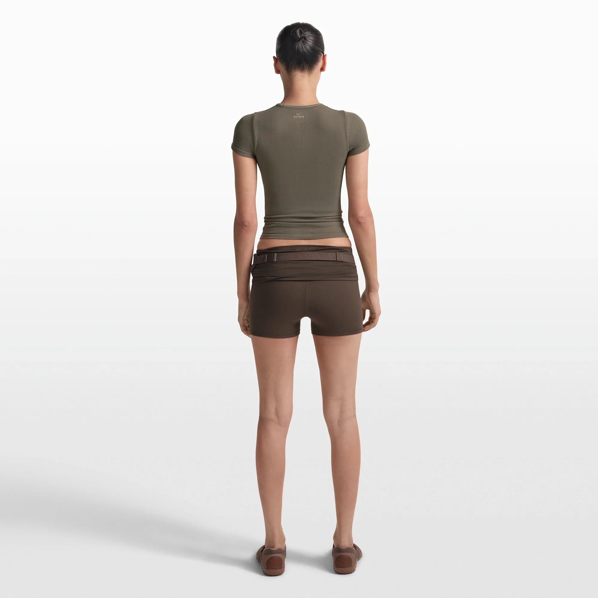 NikeSKIMS RIBBED SEAMLESS BABY TEE | DUSTY OAKMOSS/DUNE ON A MODEL FRONT VIEW @ | FOCUS: 0.0, 1.0, 0.9