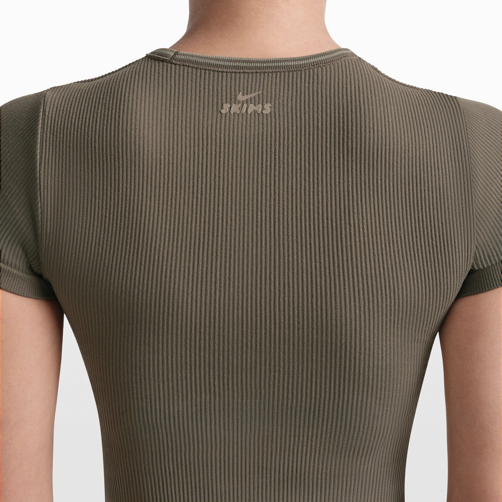 NikeSKIMS RIBBED SEAMLESS BABY TEE | DUSTY OAKMOSS/DUNE ON A MODEL FRONT VIEW @ | FOCUS: 0.0, 1.0, 0.9